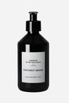 Sort flaske med pumpe, mærket "Urban Apothecary Coconut Grove", luksus hånd- og bodylotion.