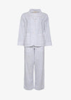 Hvid nattøjssæt med marineblå prikker, langærmet skjorte og bukser.