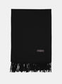 Sort cashmeretørklæde med frynser og et lille mærke, der angiver materialet, 70% cashmere.