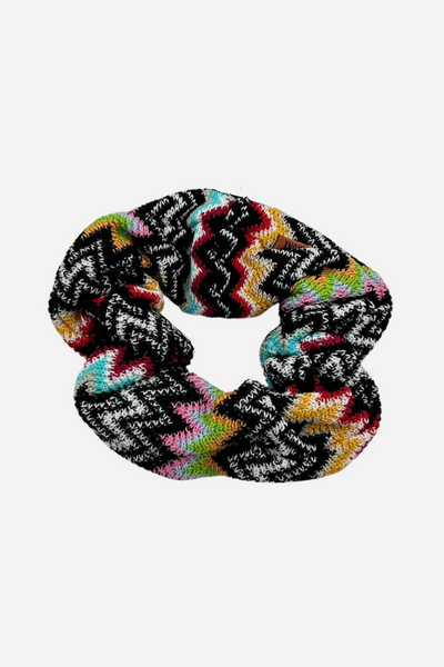 Scrunchie med zigzag-mønster i sort og flerfarvet glimmer: rød, blå, grøn og gul.