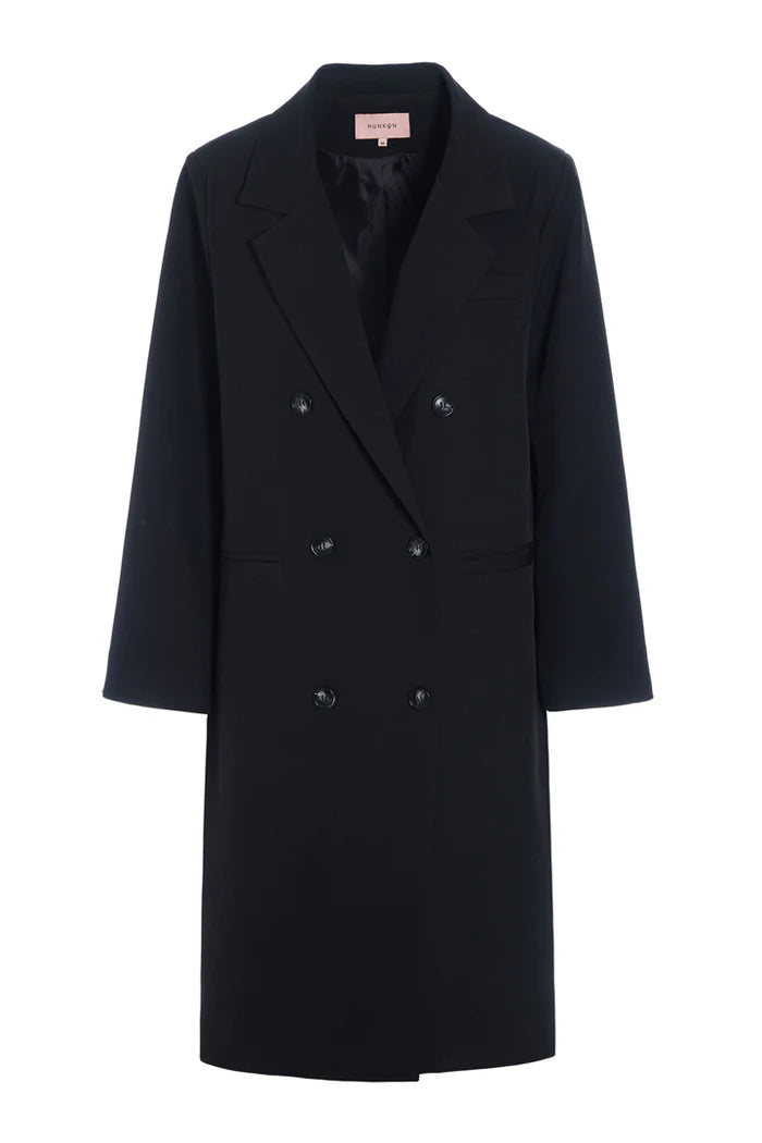 Sort trenchcoat fra Hunkøn med dobbeltradet knaplukning, lange ærmer og bagpå en slids.