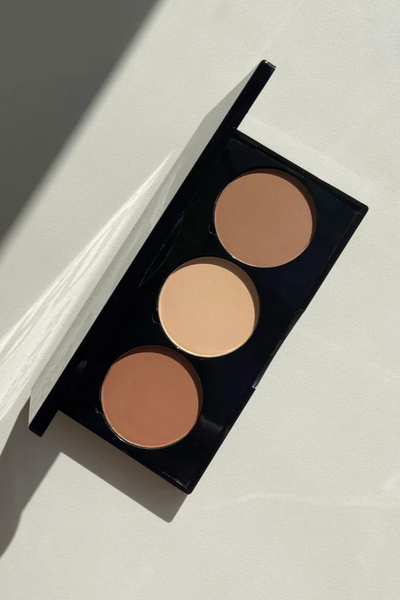 Sort makeup-palette med tre cirkulære nuancer i varierende toner, elegant og jævnt fordelt.