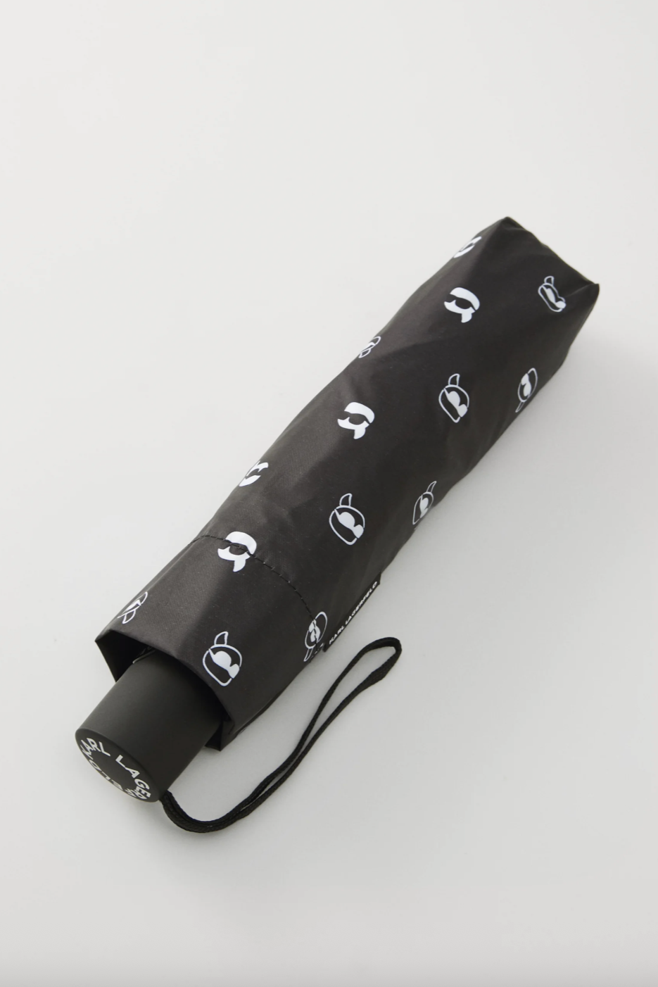Sort paraply med gentaget hvidt logo. Håndtaget viser "KARL LAGERFELD".