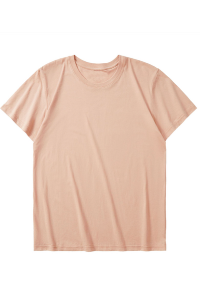 Peach pink T-shirt med korte ærmer og rund hals, liggende fladt på hvid baggrund. Enkel stil.