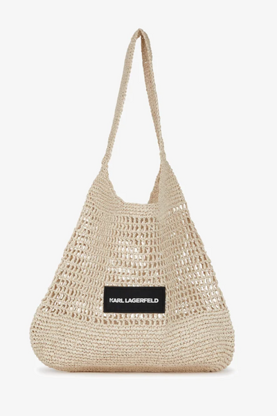 Beige, strikket strandtaske med sort "KARL LAGERFELD" label på forsiden.